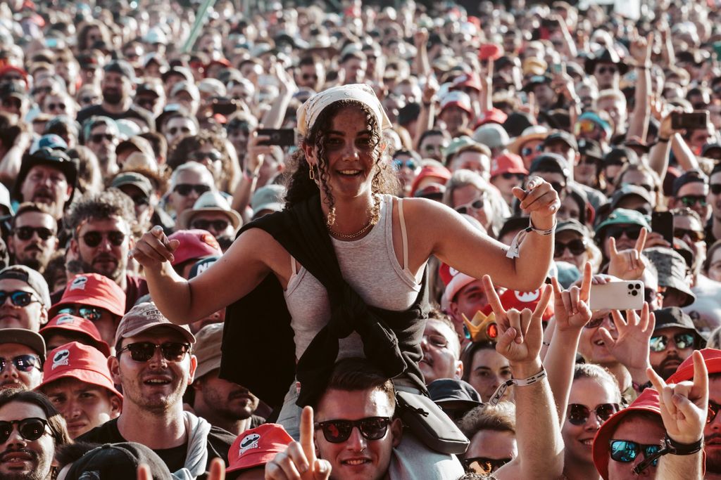 A festival-goer sitting on shoulders among the crowd