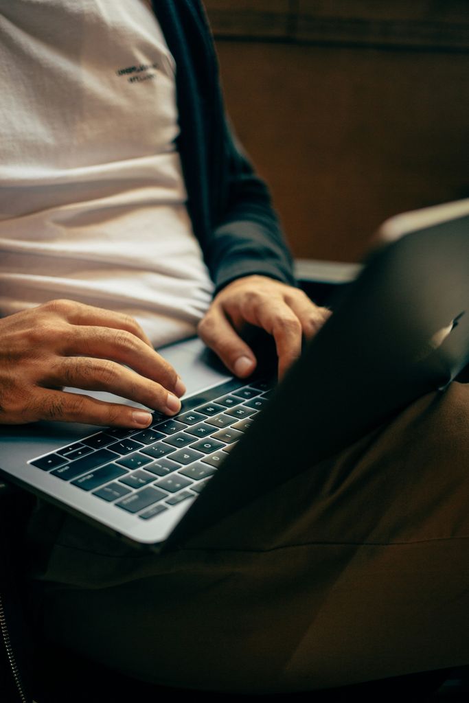 Hände tippen auf einer Laptop-Tastatur