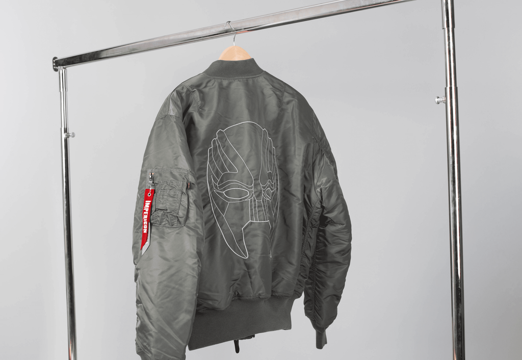 A jacket with the Marsimoto mask embroidered on the back, hung on a clothing rack
