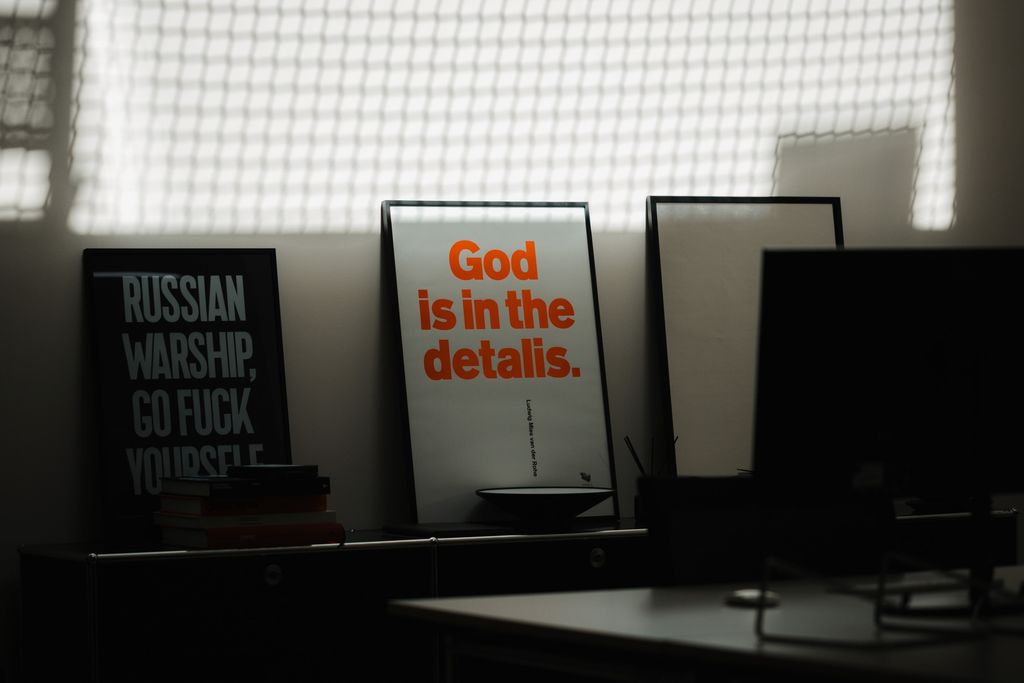 Office scene showing a picture frame with the phrase 'God is in the details.'